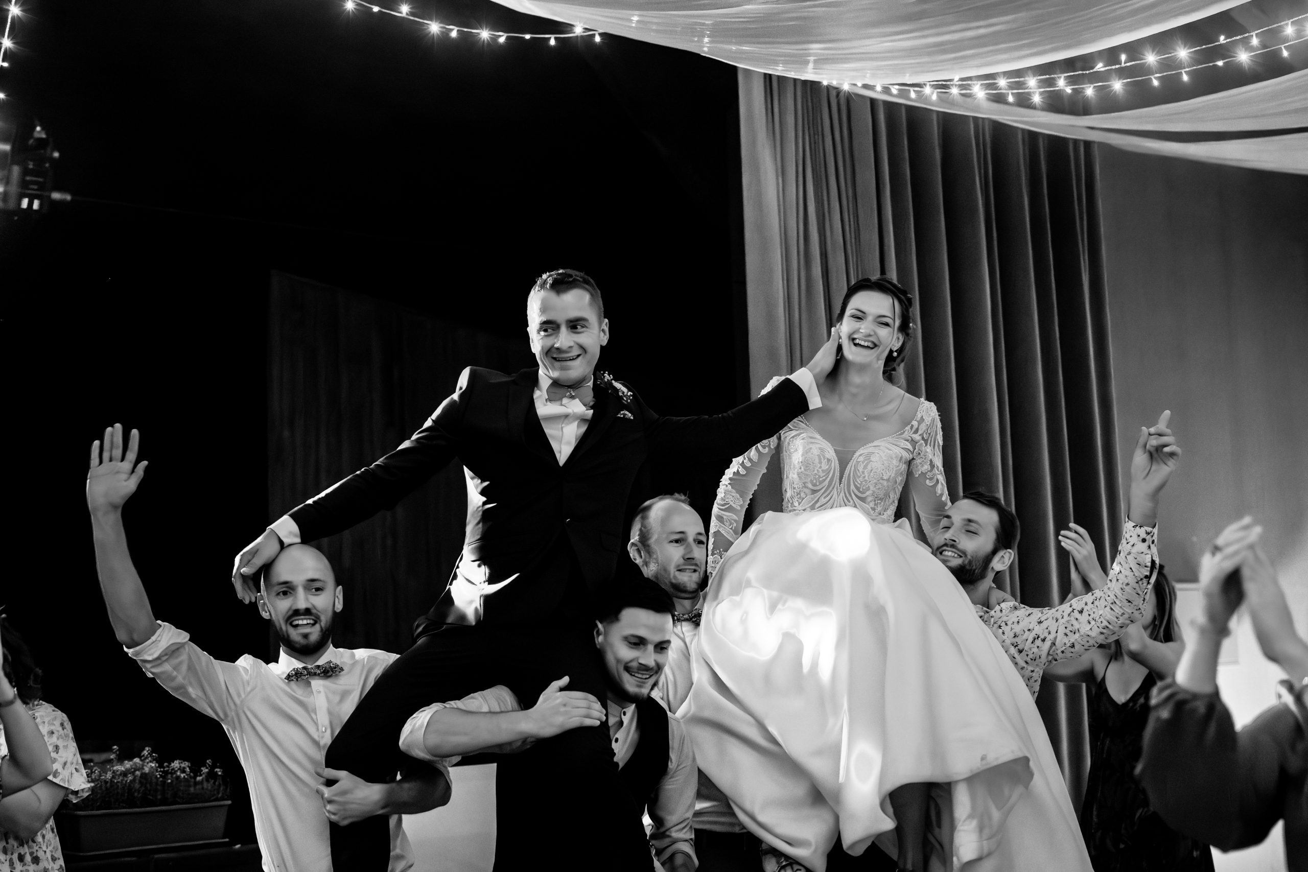 Questions au photographe mariage - Les mariés portés en triomphe par leurs proches lors de la soirée