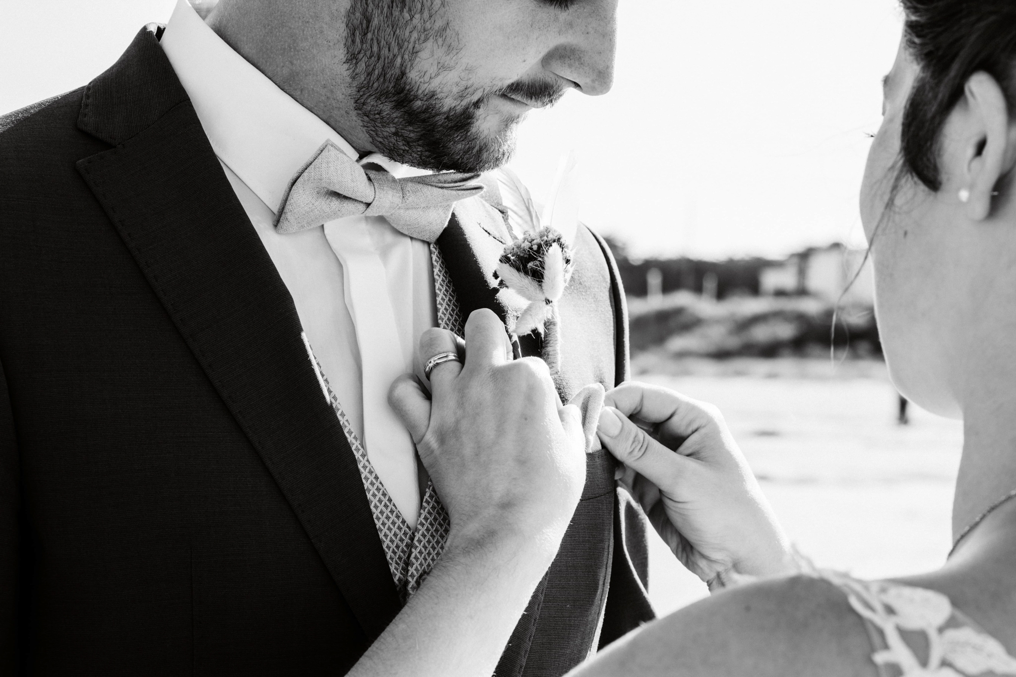 Choisir son photographe mariage - La mariée ajuste la boutonnière du marié